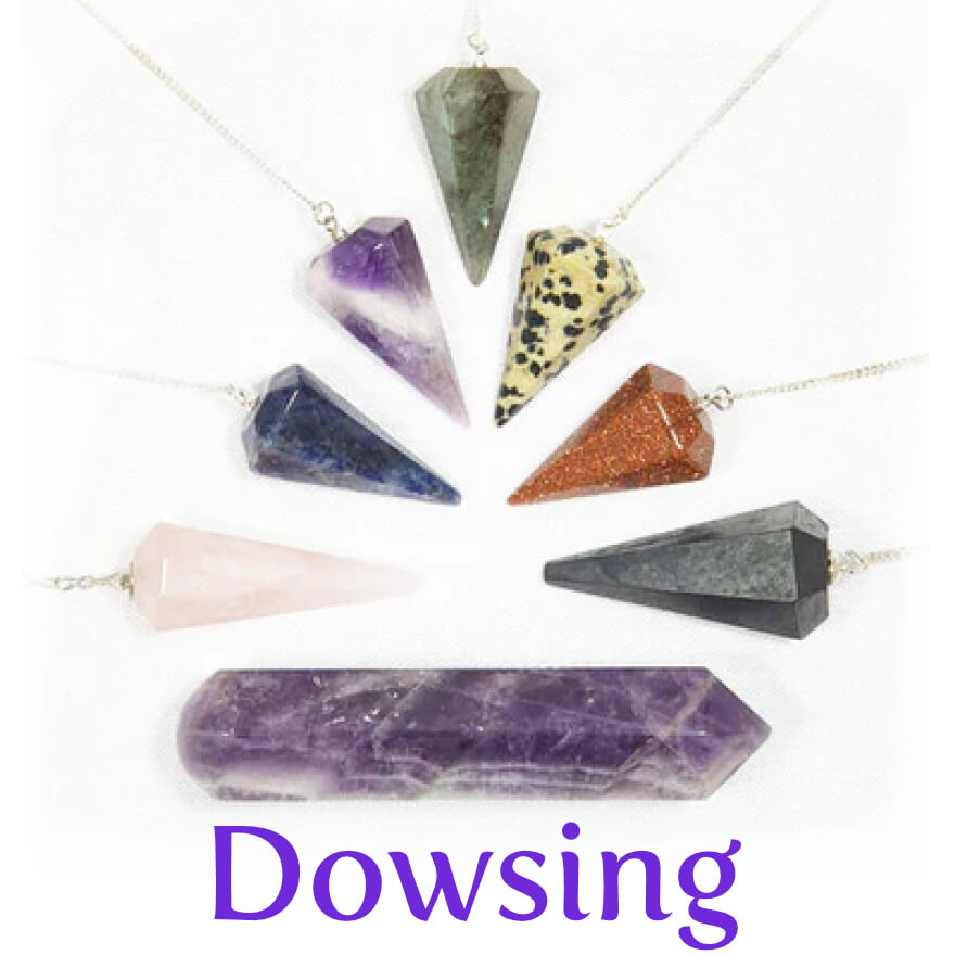 A selection of 7 crystal pendulums of different crystal types, each on a silver chain, and an amethyst wand underneath