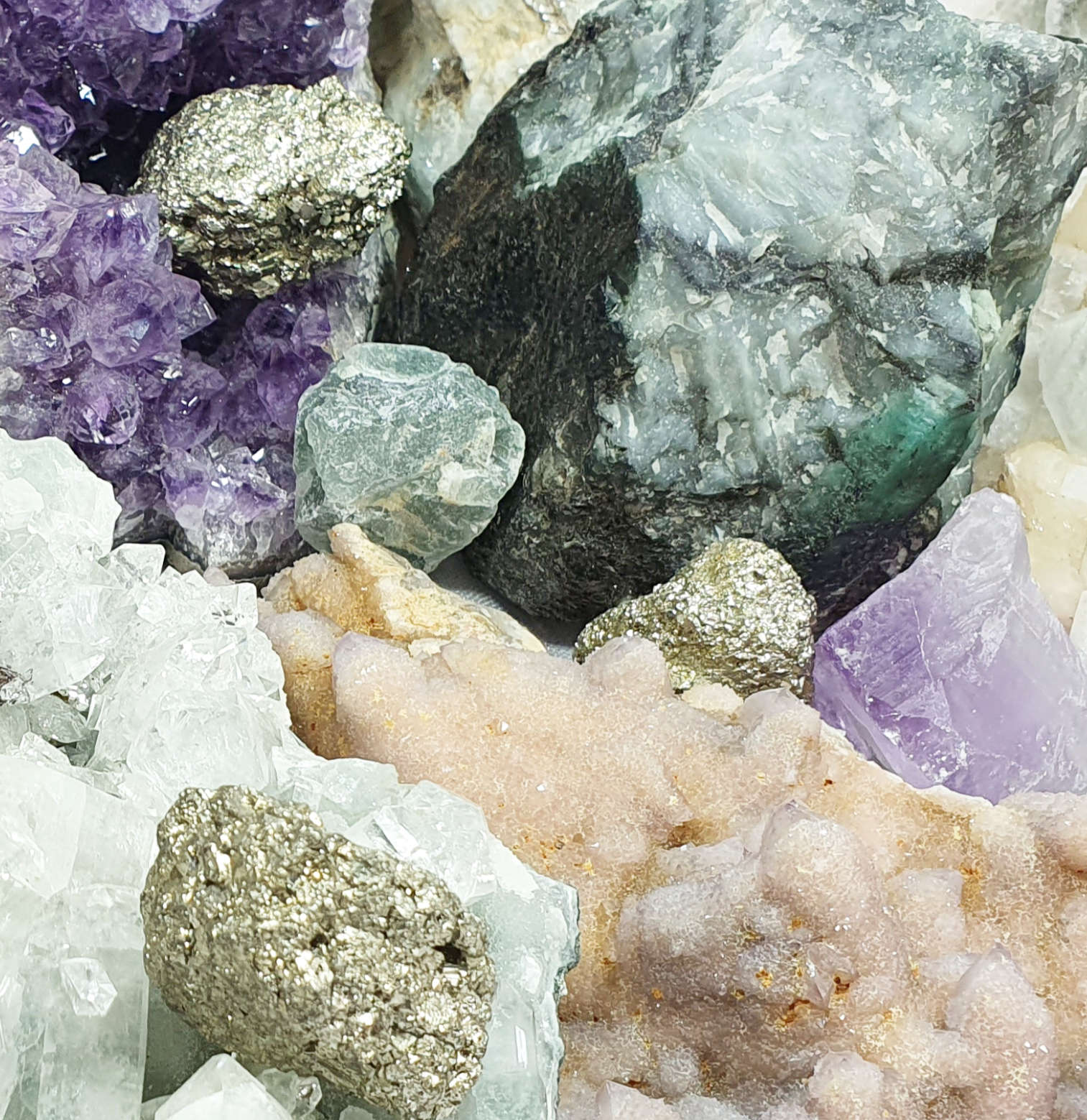 close up of several natural crystals in raw chunk and cluster forms.  Amethyst, pyrite, calcite etc.