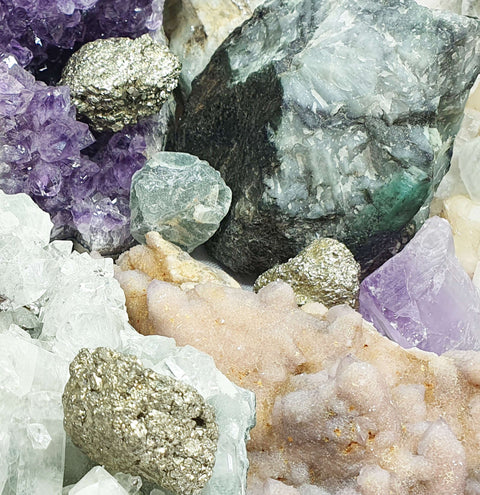 close up of several natural crystals in raw chunk and cluster forms.  Amethyst, pyrite, calcite etc.