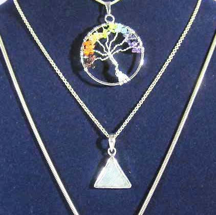 a silver chakra tree of life pendant with 7 crystal chips and a triangular crystal pendant both on silver chains